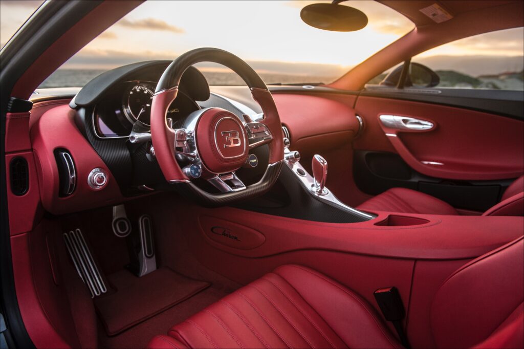 Cockpit is surprisingly roomy for such a narrowly purposed car. Front wheel wells intrude, but there’s a big dead pedal. Excellent human factors, excellent architecture. 